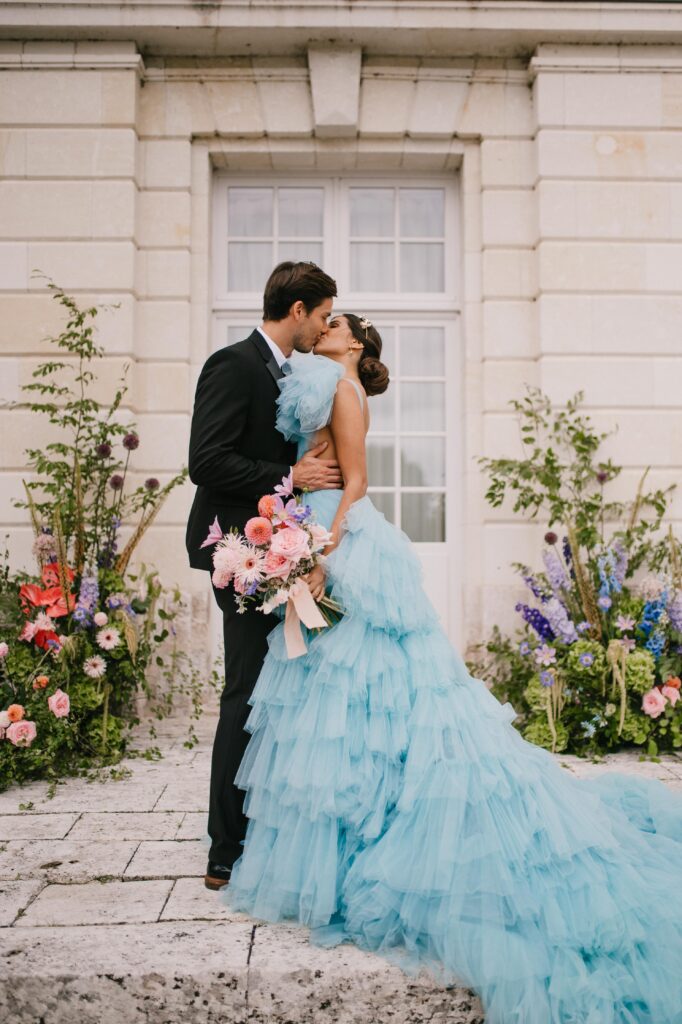 Bride and groom kissing in front of their french castle wedding. 