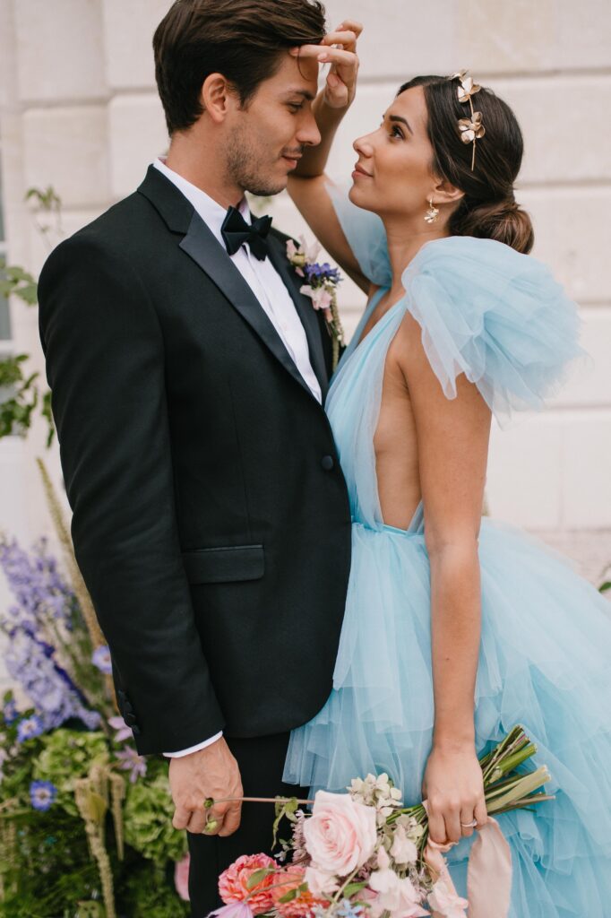 Bride and groom embracing in front of their french chateau in the loire valley near paris. 