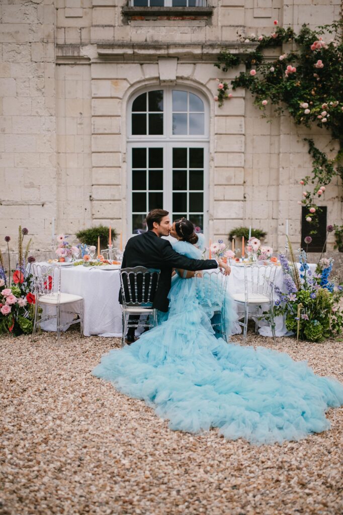 Bride and Groom sitting at their wedding reception table for the castle wedding in France. 