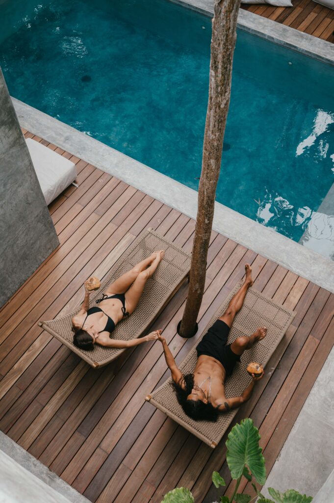 Aerial vue of couple sitting by swimming pool in Tulum villa on the morning of their Tulum elopement. 