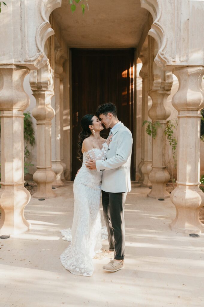 Moira and Tigue embracing by pillars at Palais Namaskar.