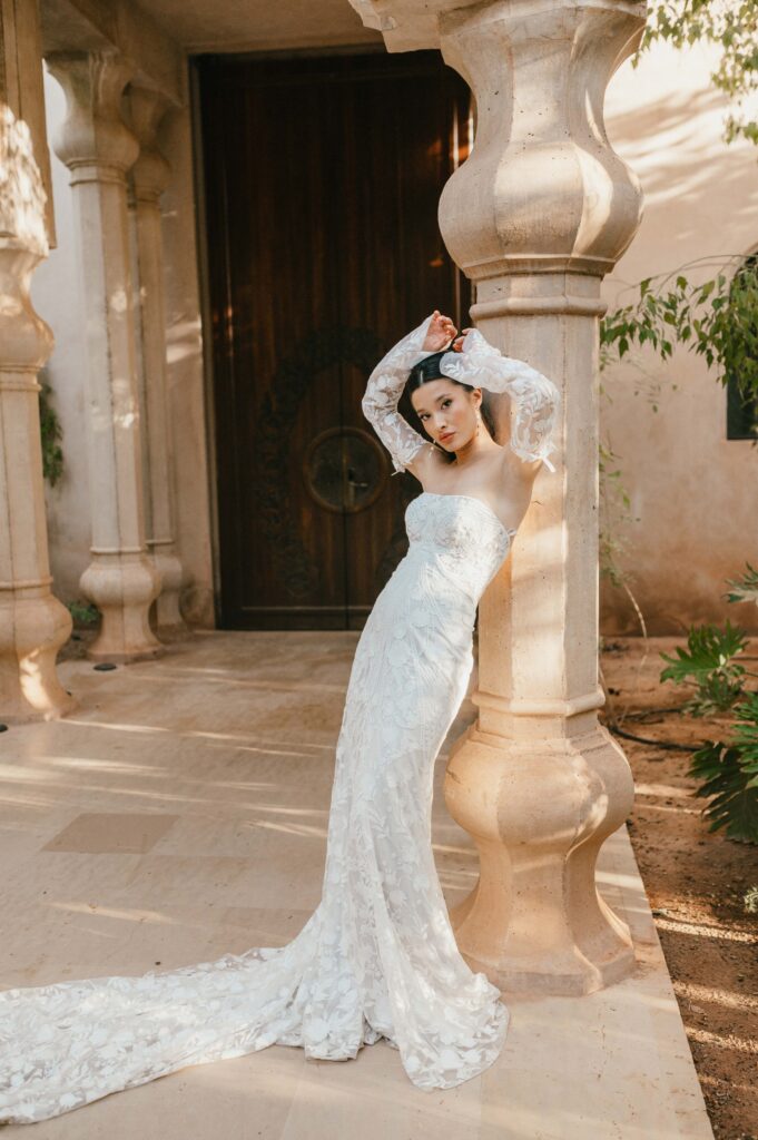 Bride Moira wearing Rue de Seine bridal leaning on pillar at Palais Namaskar Marrakech.