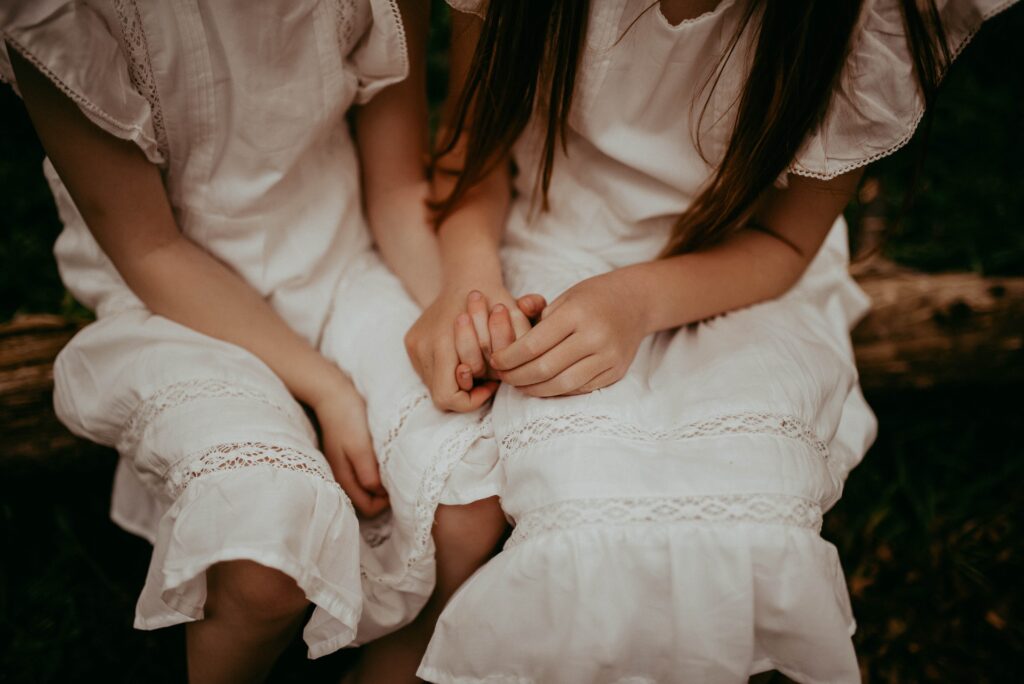 Close up of two sisters holding hands. 