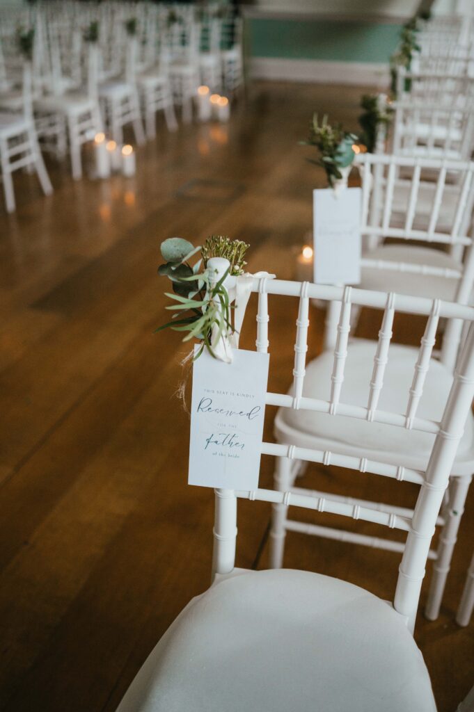 Close up of chairs in the ceremony room at Botleys Mansion. Sign reads "reserved for the father of the Bride".