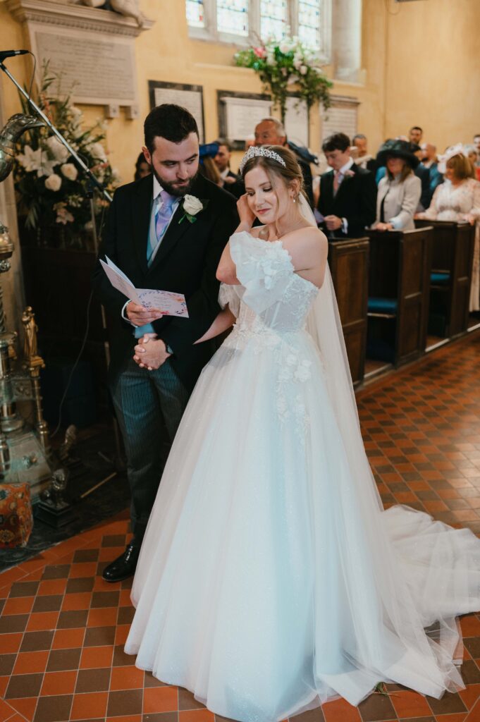 Amanda and John exchanging heartfelt vows during their emotional ceremony at St. Mary the Virgin Church.