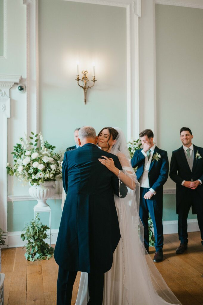 Charlie embracing her father with Martin, in the background, wiping a tear.