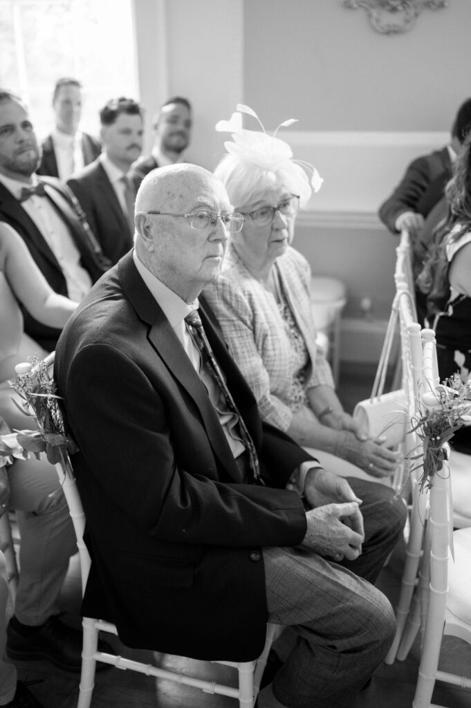 Charlie's grandparents watching the ceremony with attention and emotion.