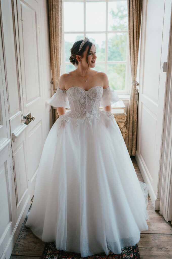 Amanda looking radiant in her elegant wedding dress, with a joyful expression on her big day at Kingston Bagpuize House.