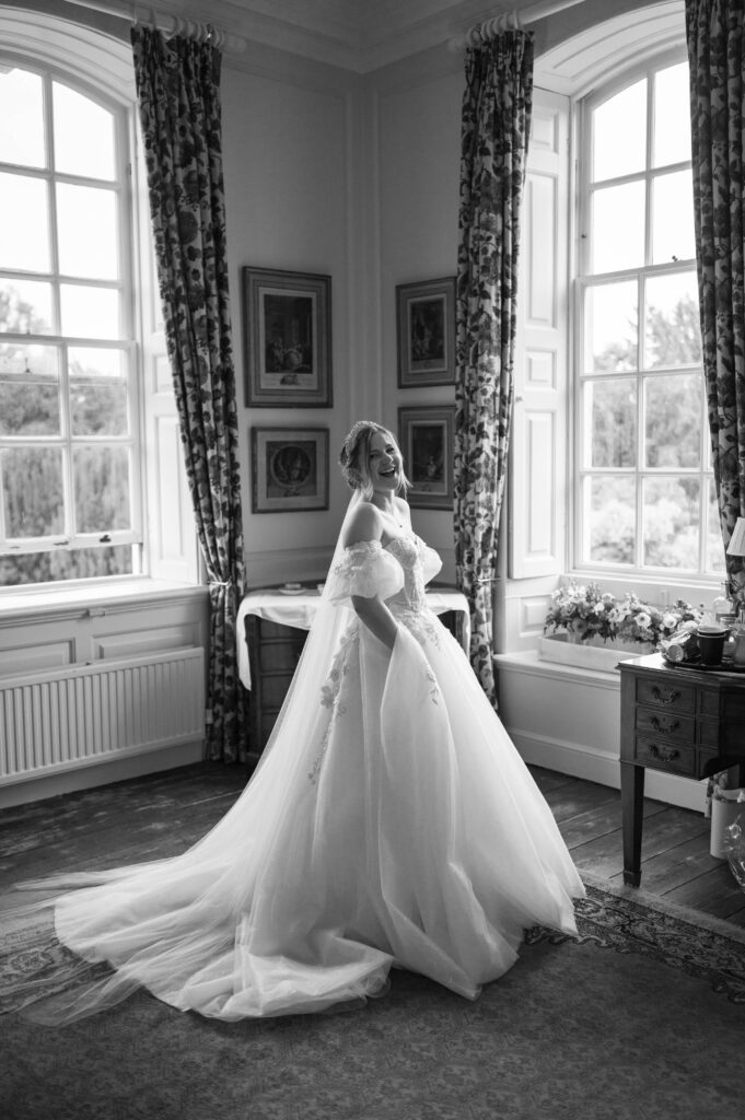 Amanda standing elegantly in her wedding dress, radiating beauty and excitement on her wedding day.