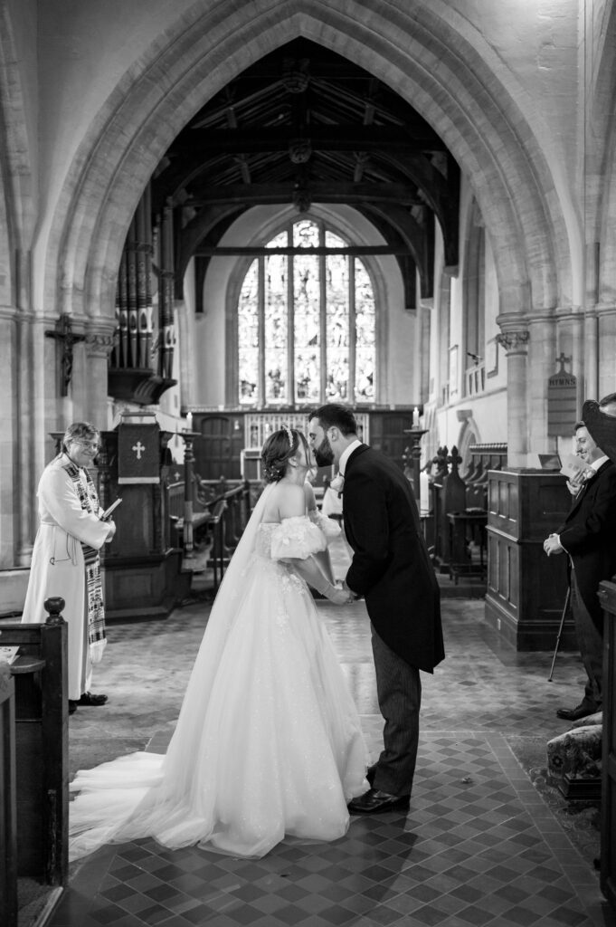 Amanda and John sharing their first kiss as a married couple at St. Mary the Virgin Church.