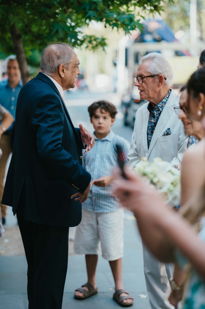 Candid photos of family members meeting for the first time in front of Chelsea Town Hall before Raissa and Vasileios wedding ceremony. 