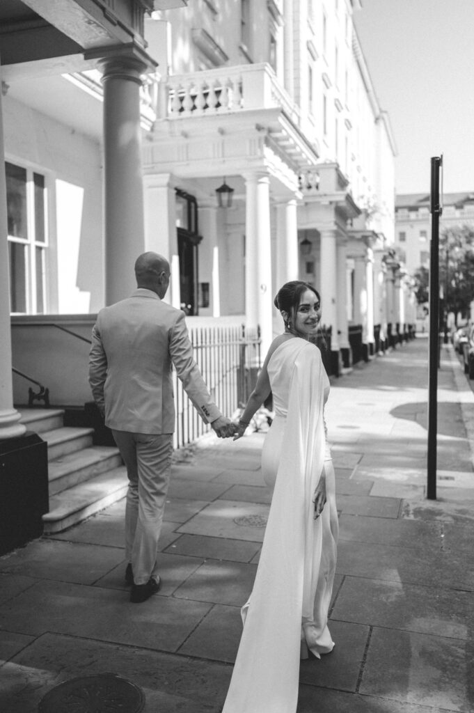 The couple walks hand-in-hand along the peaceful pathways of Warwick Square.