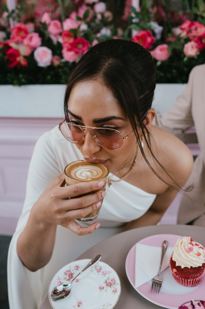 Close up of Raissa sipping her coffee at Peggy Porschen Café. 