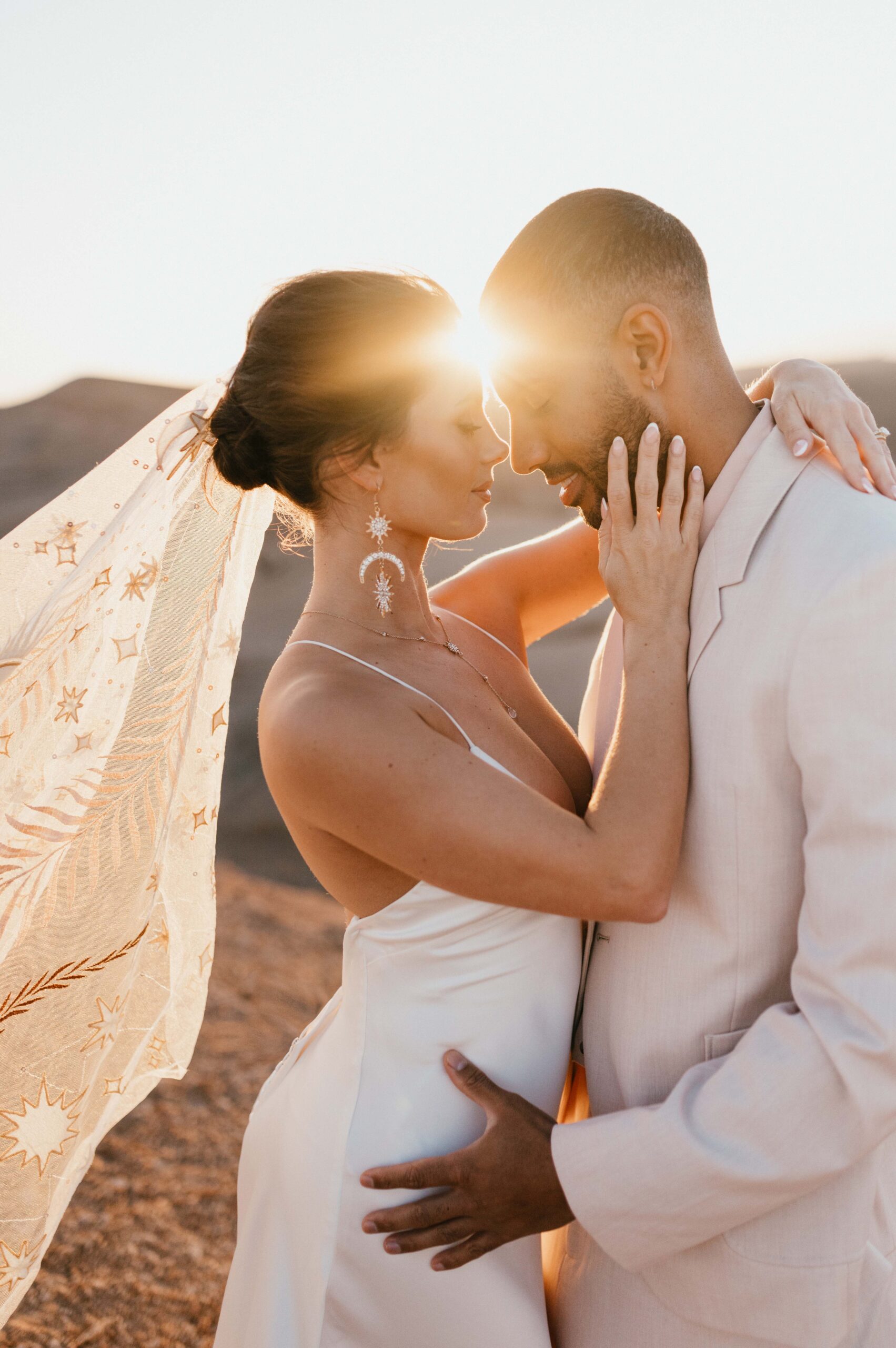 A breathtaking sunrise over the Atlas Mountains during Megan and James' Marrakech desert elopement, with the couple sharing a quiet moment in the warm glow.